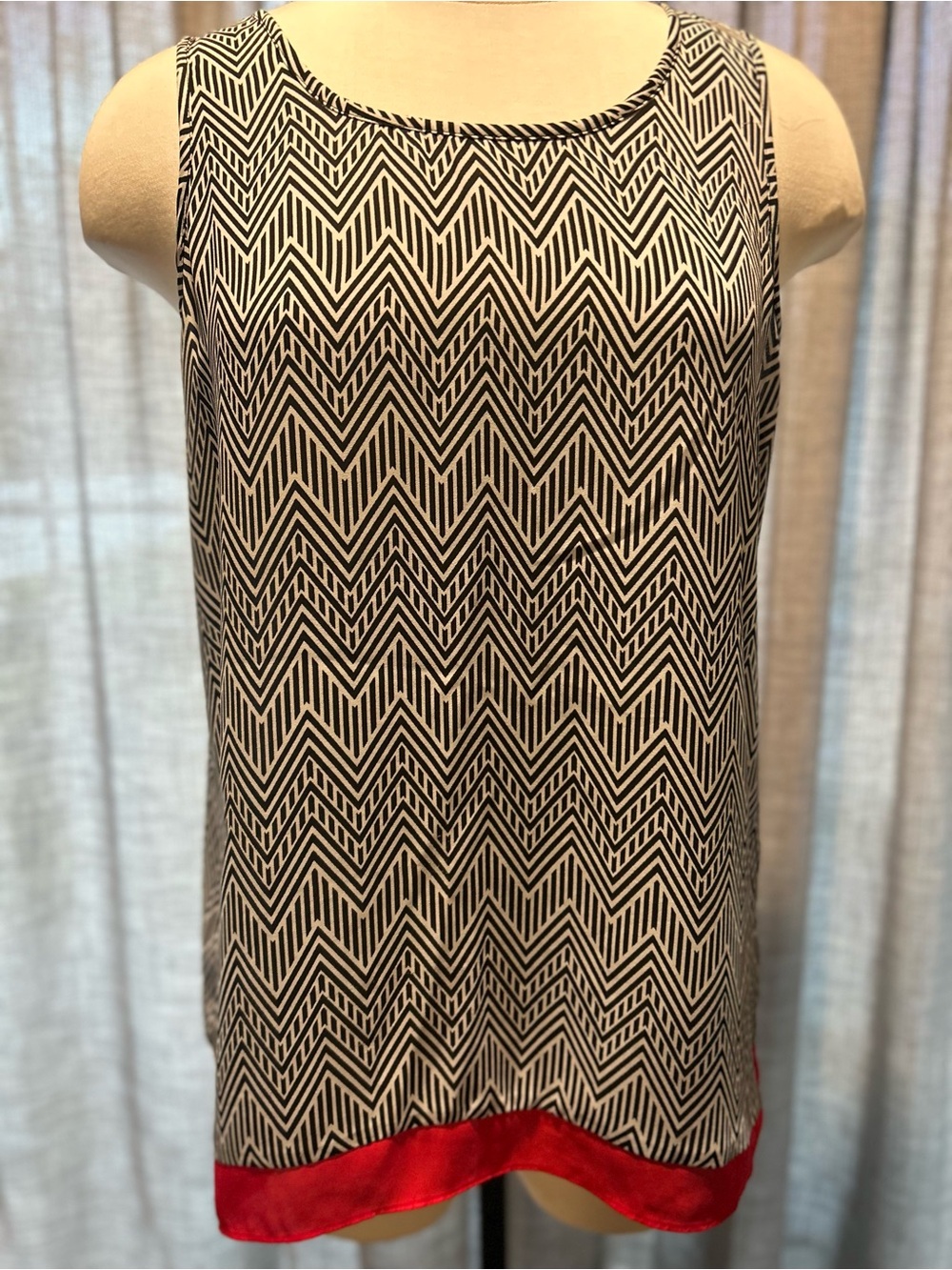 Women’s lightweight sleeveless blouse with black & white pattern and red accent.